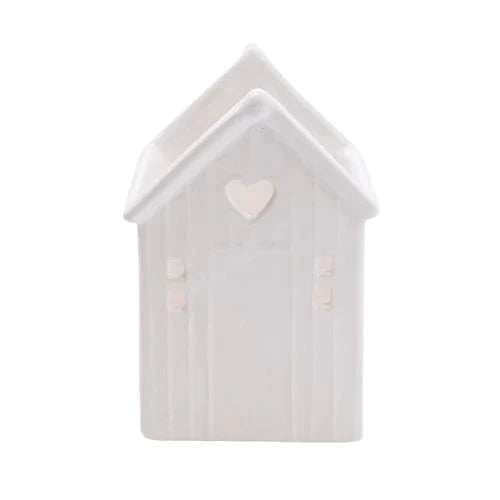 Beach Hut Tealight Holder White, a charming ceramic candle holder that adds warmth to any space with its cute beach hut design.