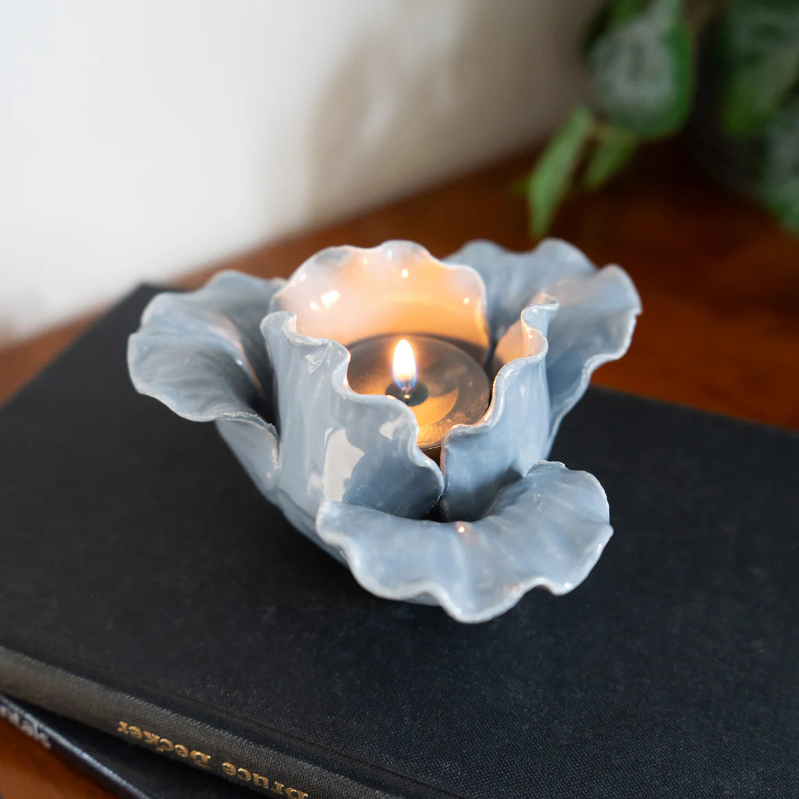 Stylish display of the Flower Shaped Tealight Holder - Blue on a wooden table, highlighting its charm as a flower tealight holder.