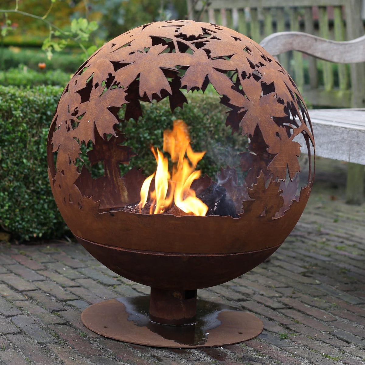 Rust fire ball featuring laser cut leaves, perfect for your outdoor space; a unique laser cut fire pit.