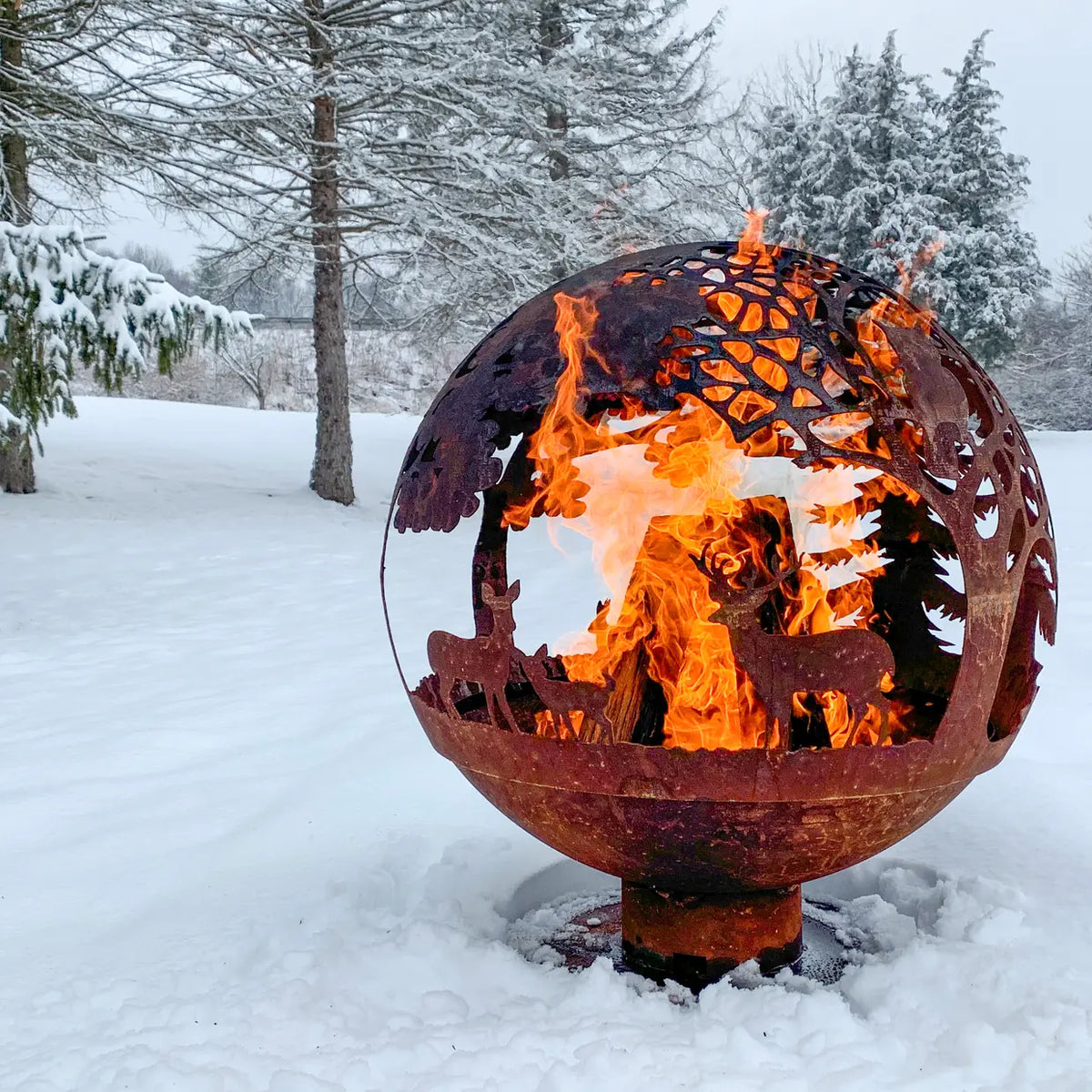 Family enjoying a cozy evening around the fire ball laser cut rust woodland laser cut fire pit.