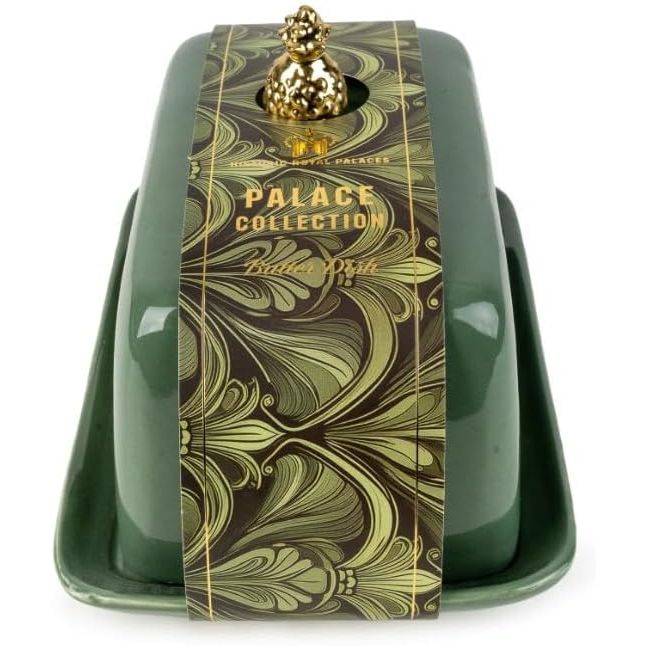 Green butter dish with decorative label and gold accents on a white background