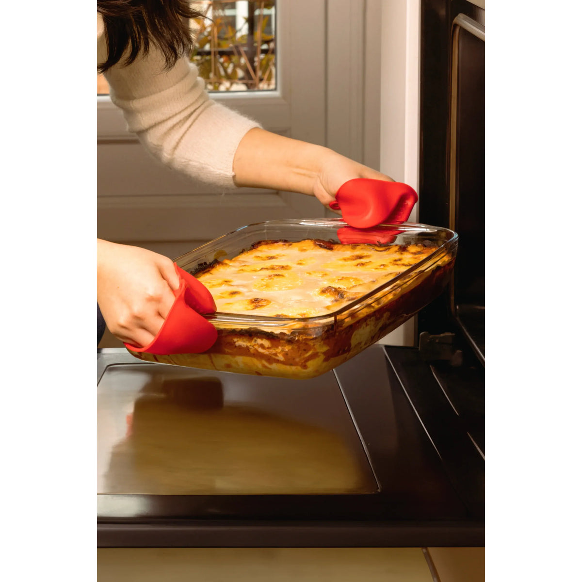 O'Cuisine Large Roasting Dish being removed from the oven, showcasing its versatility for baking lasagna.