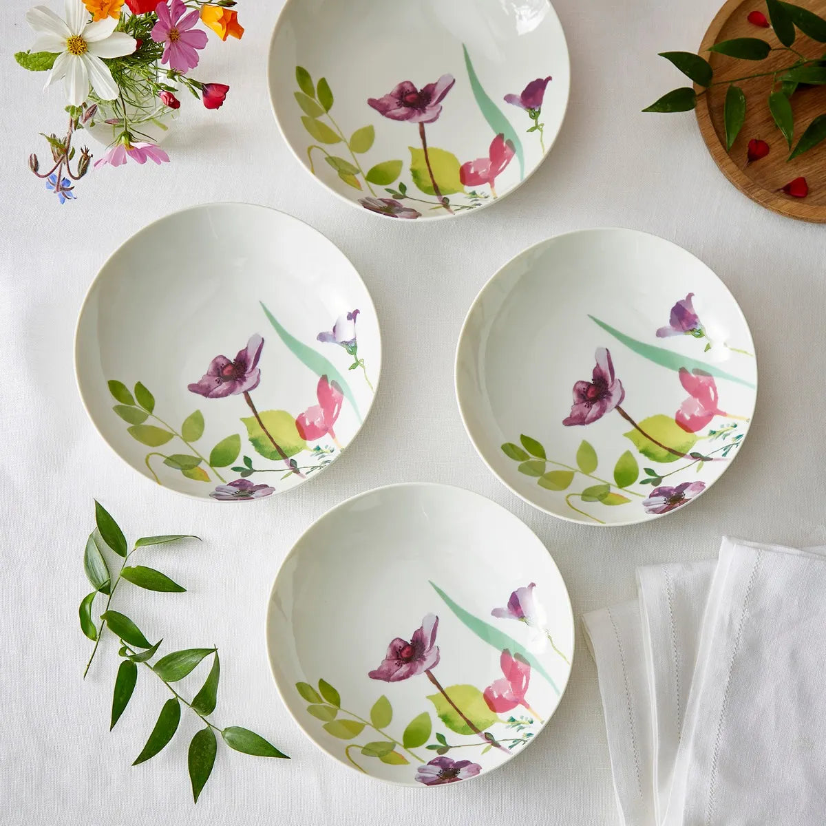 The Portmeirion Water Garden Pasta Bowl Set of 4 presented on a dining table, ready for delicious meals, emphasizing the bowls' decorative floral pattern and functionality for serving pasta.