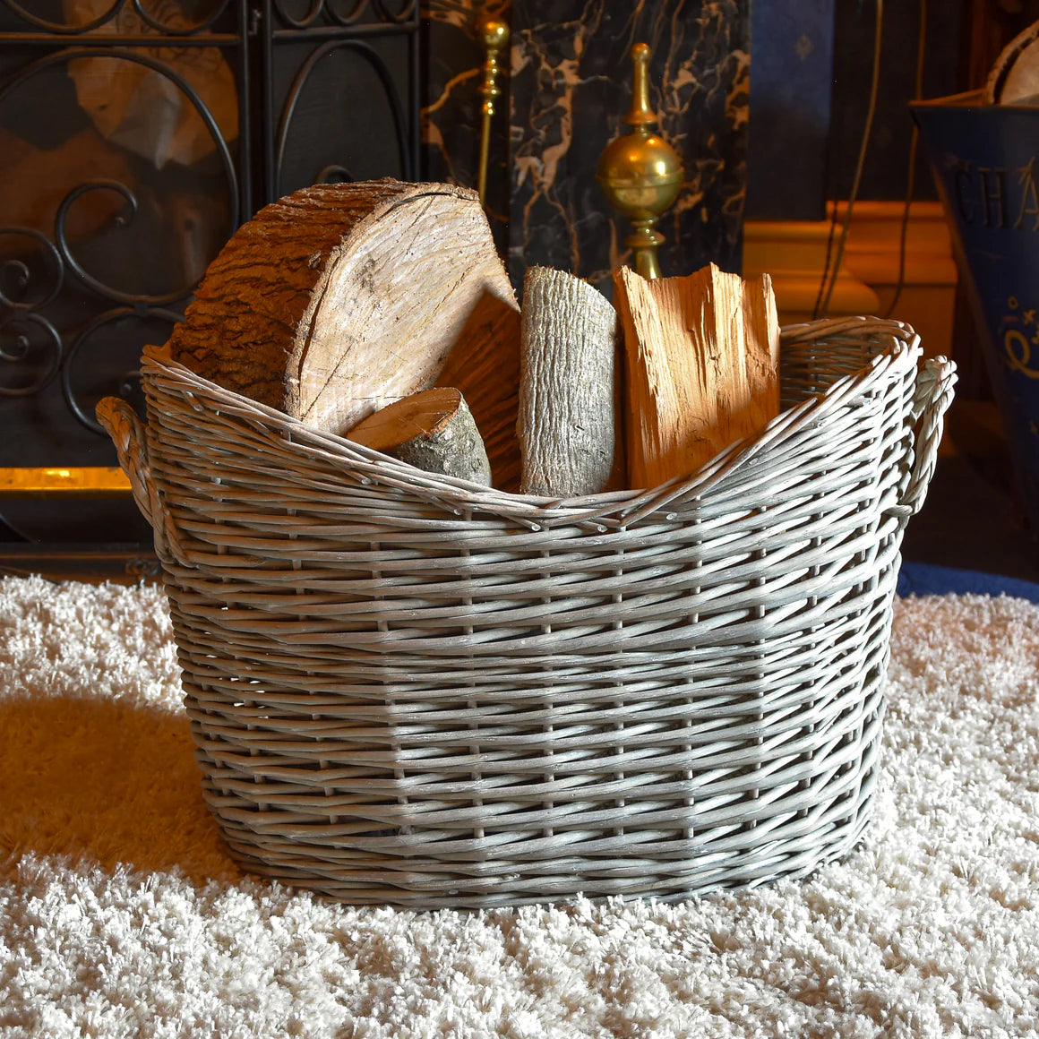 An elegant oval scoop log basket perfect for firewood storage, demonstrating the beautiful wicker log basket design by Home Deco London.