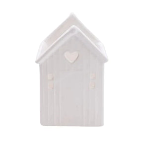 Beach Hut Tealight Holder White, a charming ceramic candle holder that adds warmth to any space with its cute beach hut design.
