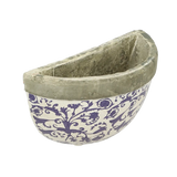 Aged ceramic wall planter styled with trailing plants, ideal for a contemporary look.