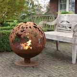Close-up of the rust fire ball with intricate laser cut leaves; a stunning laser cut fire pit for cosy gatherings.