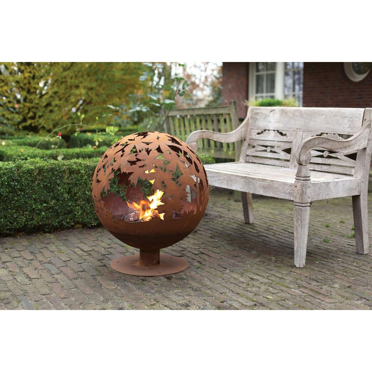 Rust fire ball design with laser cut leaves glowing in the light; an attractive laser cut fire pit for evening warmth.