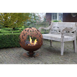 Outdoor setting with the rust fire ball featuring laser cut leaves; a stylish laser cut fire pit for your backyard.