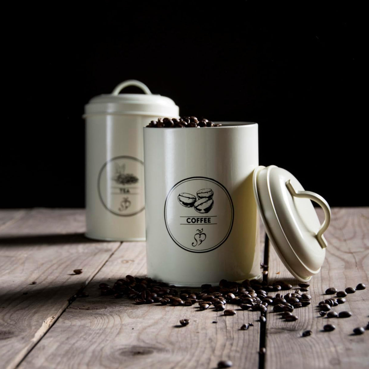 Elegant cream coloured farmhouse kitchen storage canisters for tea, coffee, and sugar.