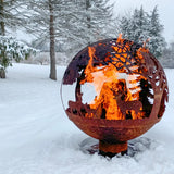 Family enjoying a cozy evening around the fire ball laser cut rust woodland laser cut fire pit.