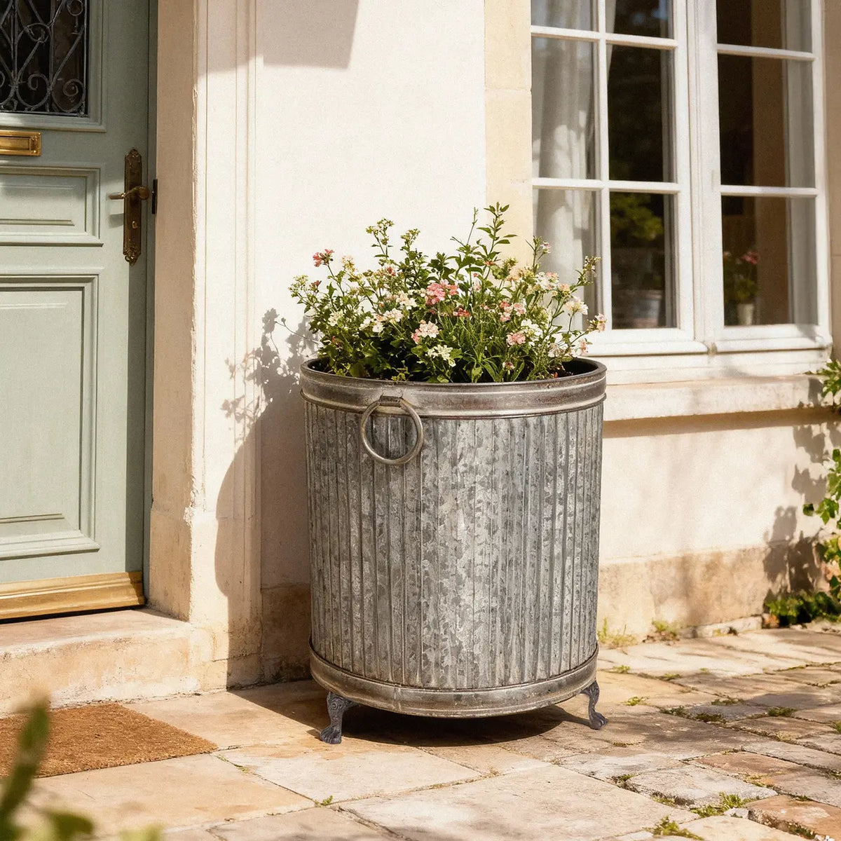 Set of 3 round footed zinc planters showcased with a decorative ribbed surface and strong cast iron legs, perfect for enhancing garden spaces, ideal for flowers and herbs as stylish zinc footed planters.