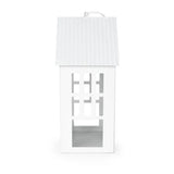 24cm Town House Lantern in White displayed with a candle inside, illustrating a decorative metal lantern's warm glow and charming appeal.