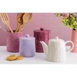 Mason Cash in The Meadow Teapot 800ml amidst kitchen utensils and decorative jars, exemplifying its role as a beautiful durable stoneware teapot.