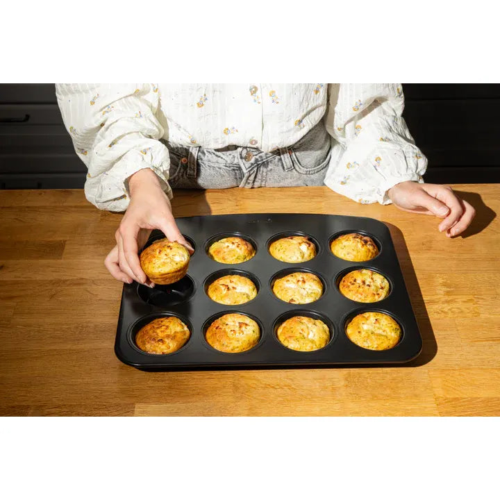 Pyrex Glide 12 Muffin and Cupcake Tray displayed with muffins, emphasizing its non-stick properties for easy baking.