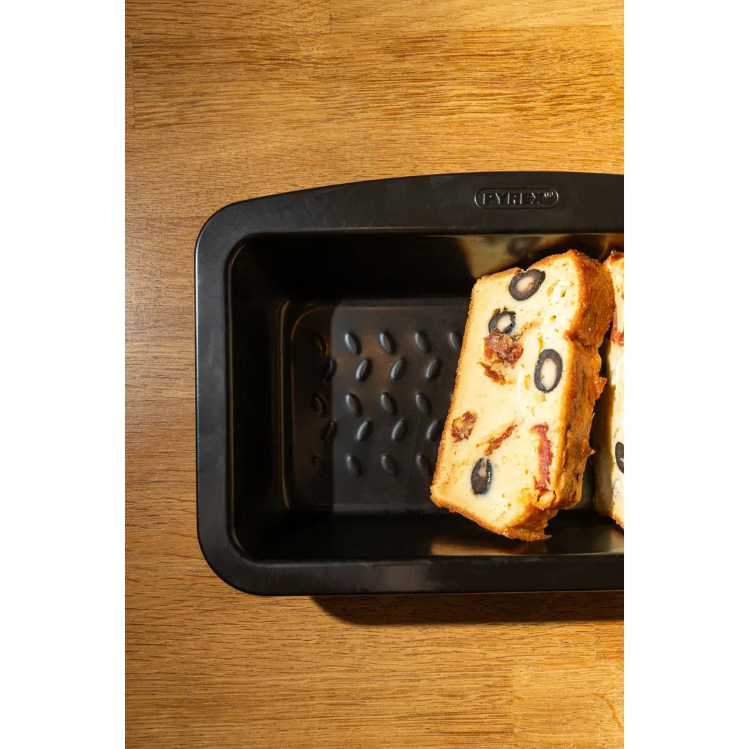 Pyrex Glide Loaf Tin displayed with delicious baked goods, highlighting its effectiveness as a non-stick loaf tin.