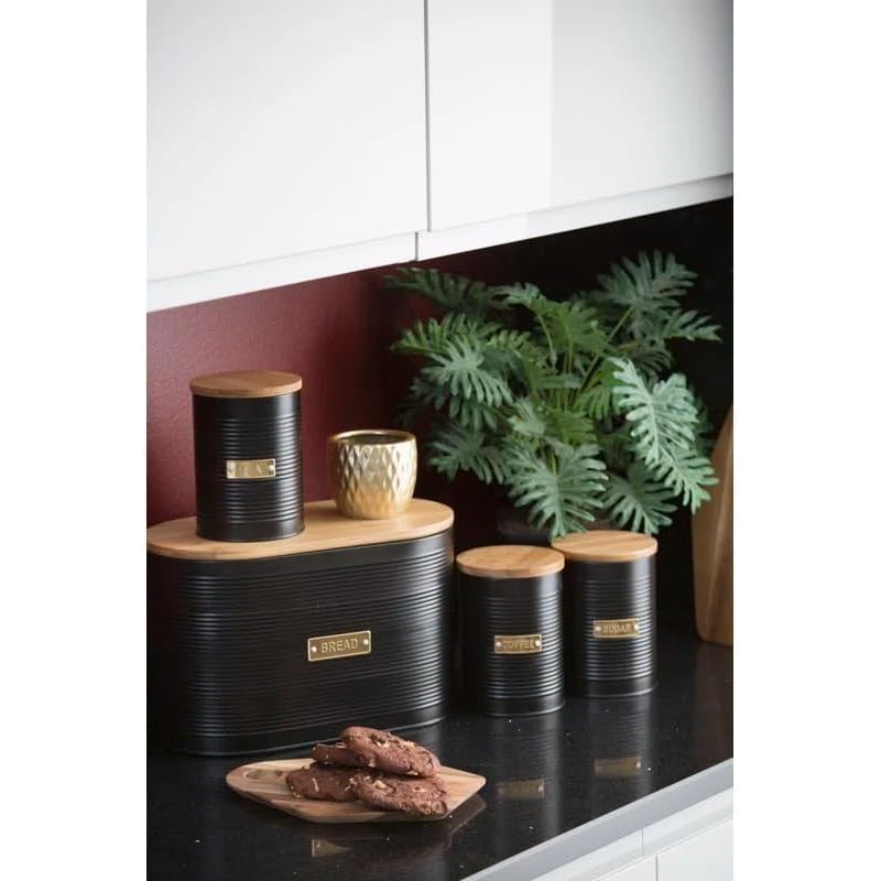 Typhoon Otto Kitchen Storage Canister Set arranged in a kitchen setting with decorative elements, including black metal canisters and a bamboo-lidded bread bin, showcasing perfect kitchen storage.