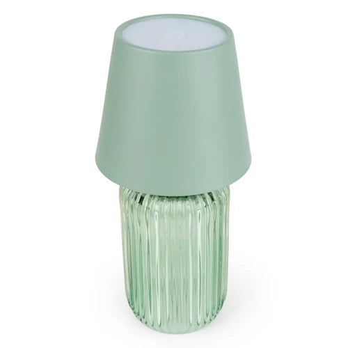 Scenic view of the Ridged Glass Table Lamp - Green on a table, a chic green table lamp for ambient lighting.