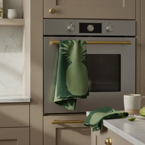 Set of two printed tea towels Pineapple design on vibrant green backdrop, ideal for a tropical kitchen ambiance.