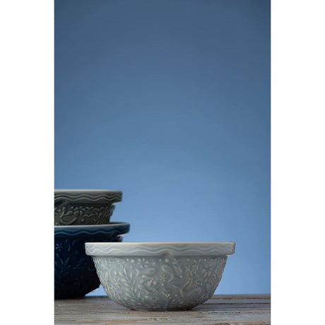 Mason Cash Nautical S24 24cm Mixing Bowl - a light blue stoneware nautical mixing bowl displayed with dark blue and green bowls, highlighting its elegant design.