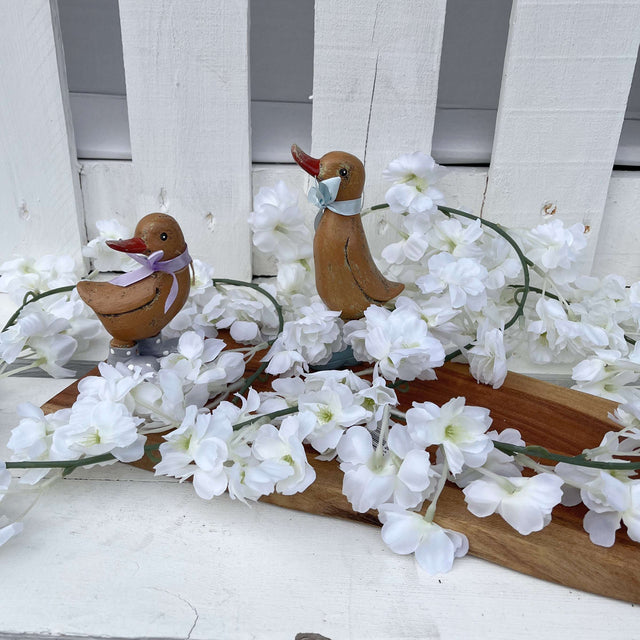 Silk Cherry Blossom Garland, Cream displayed elegantly on a mantlepiece, showcasing the beauty of the silk cherry blossom garland.