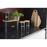 Typhoon Otto Black Set Of 3 Tea/Coffee/Sugar Storage showcasing tea storage canisters alongside wooden boards and greenery, creating a warm kitchen vibe.