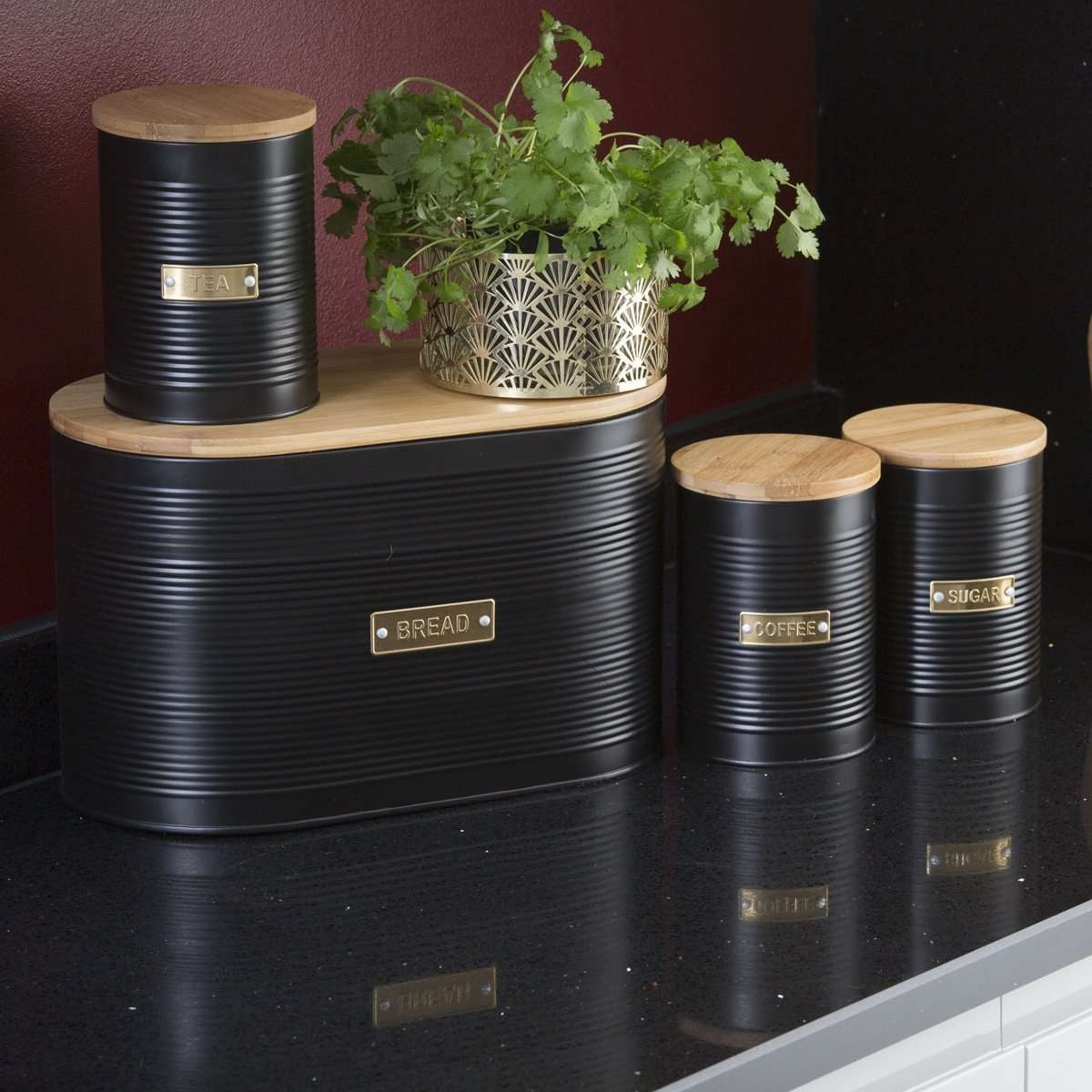 Typhoon Otto Black Set Of 3 Tea/Coffee/Sugar Storage featuring tea storage canisters grouped with green plants, enhancing a modern kitchen setting.