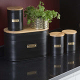 Typhoon Otto Black Set Of 3 Tea/Coffee/Sugar Storage featuring tea storage canisters grouped with green plants, enhancing a modern kitchen setting.