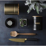 Typhoon Otto Black Set Of 3 Tea/Coffee/Sugar Storage with tea storage canisters and kitchen utensils against a dark background, showcasing a chic arrangement.